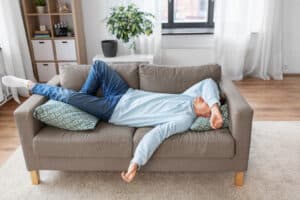 Man lying on the couch looking tired, reflecting the potential impact of genetic factors on metamyelocyte count