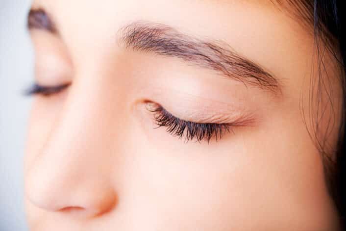 An image of an eye with double eyelashes, representing the genetic factors behind this rare trait.