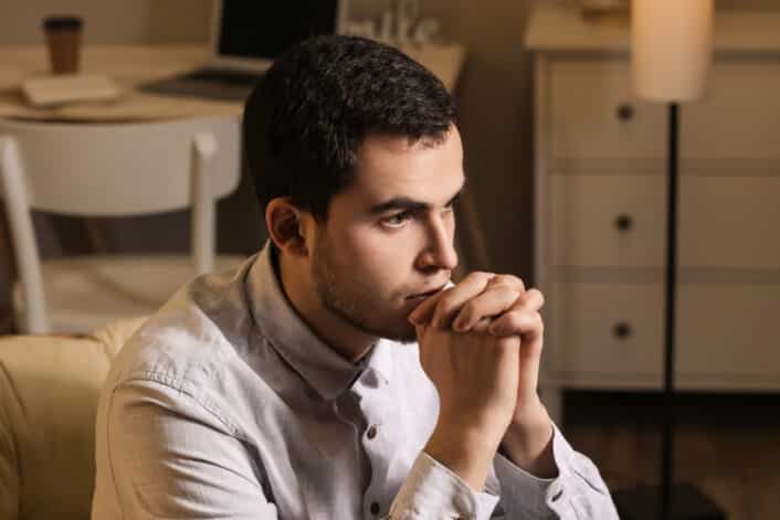 An image of a man deep in thought, representing the challenges and genetic factors linked to male infertility.