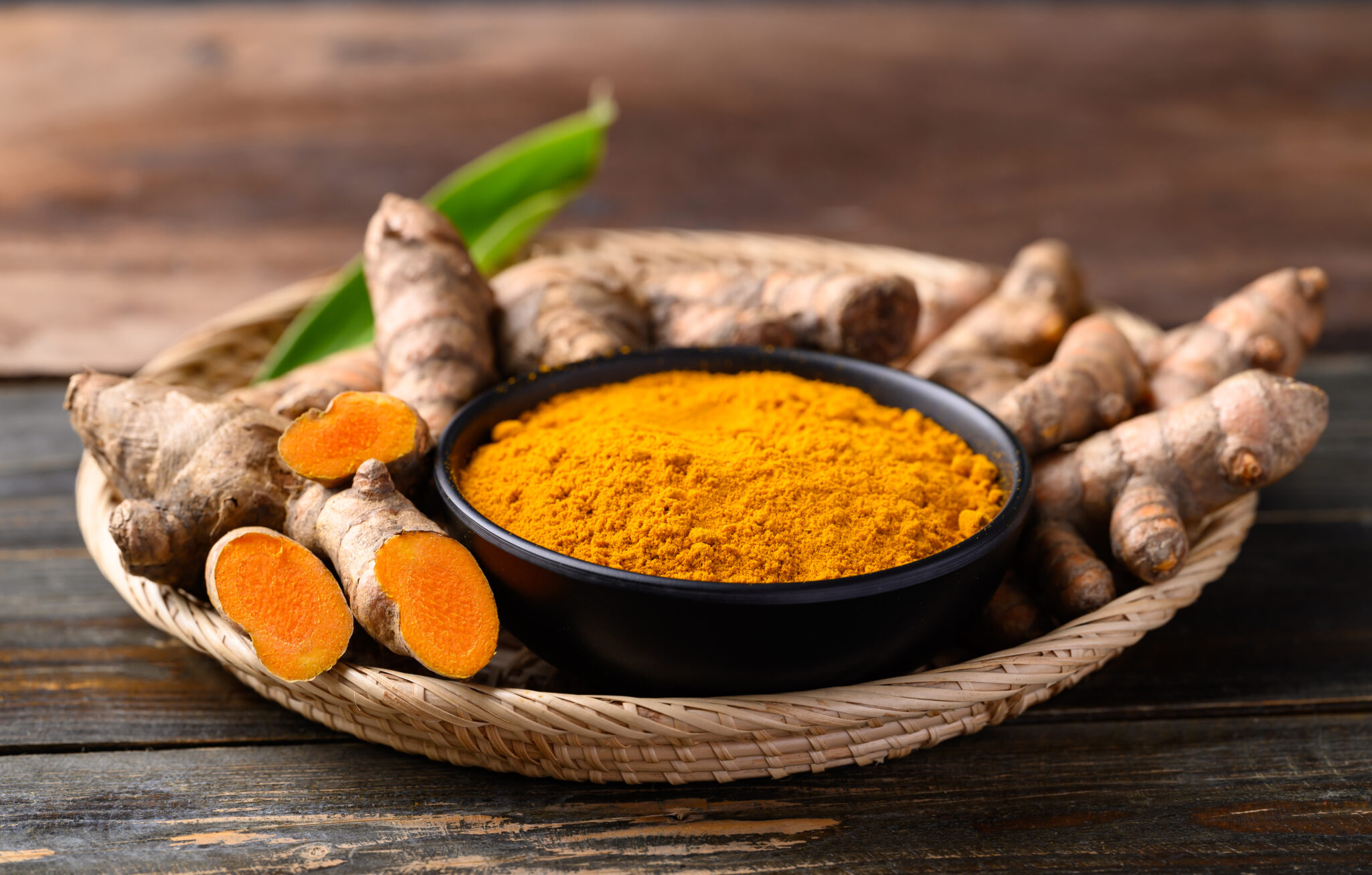 Fresh turmeric roots and powder, representing curcumin’s role in gene expression and health benefits