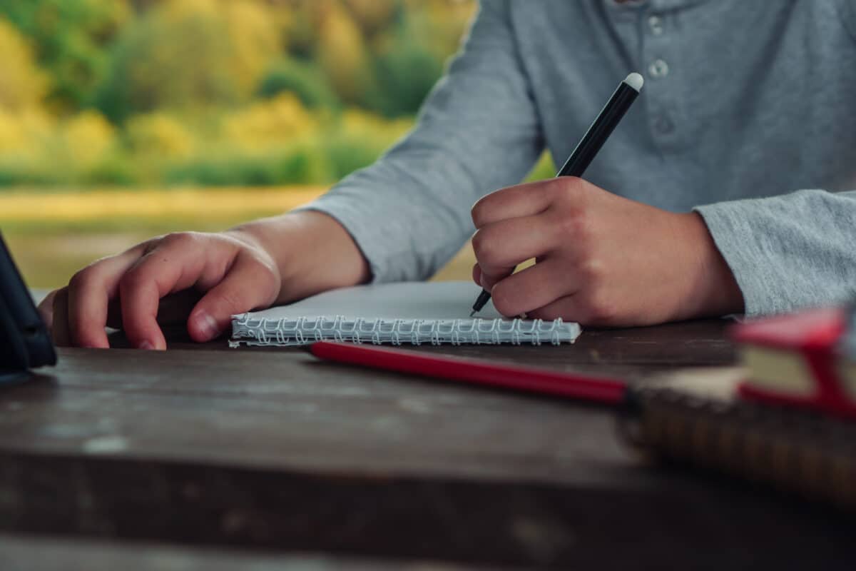 Person writing with their left hand, representing the genetic basis of left-handedness and health links