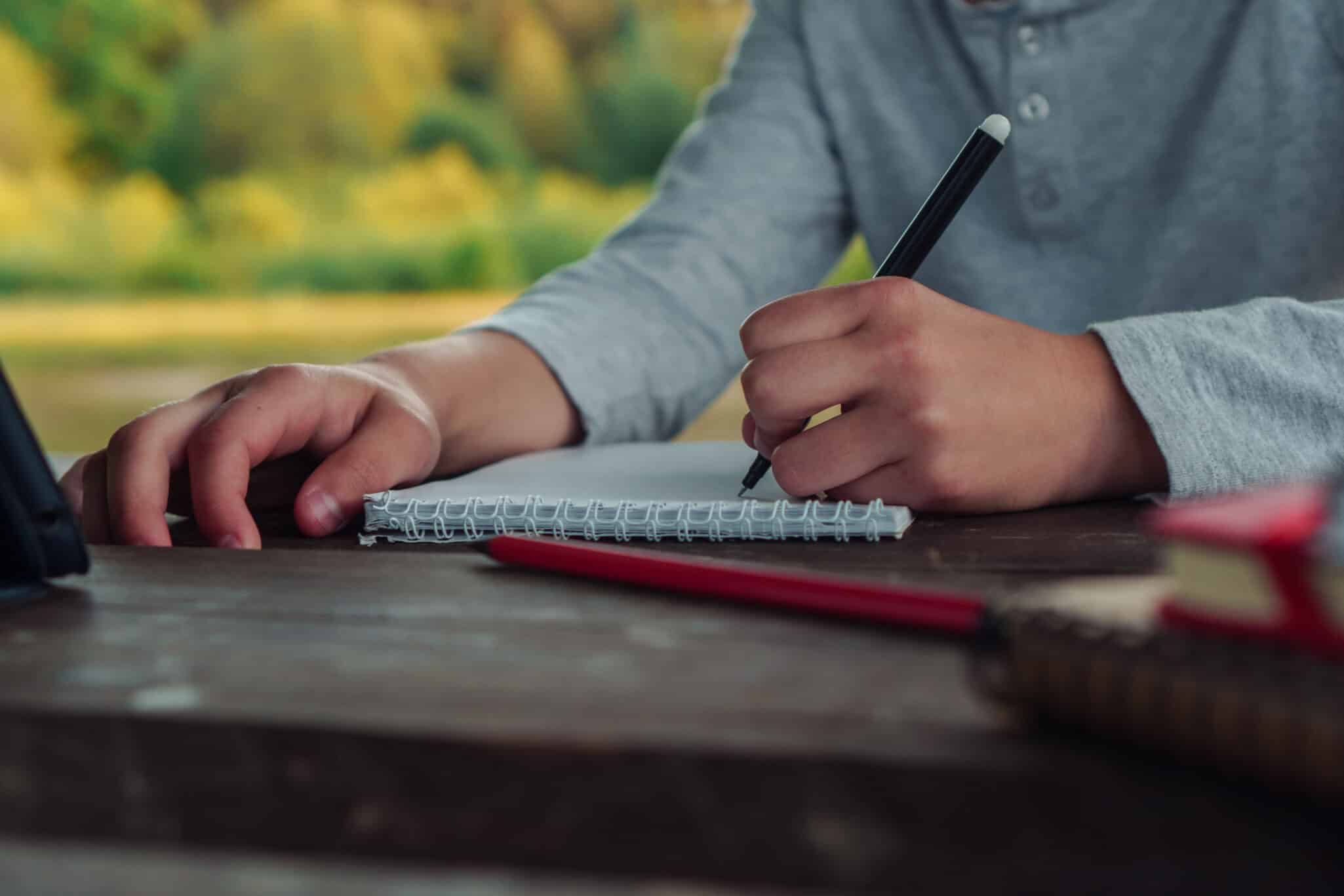 Person writing with their left hand, representing the genetic basis of left-handedness and health links
