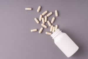 This image features a set of white lithium orotate supplement pills alongside a DNA model, emphasizing the connection between genetics and individual response to the compound.