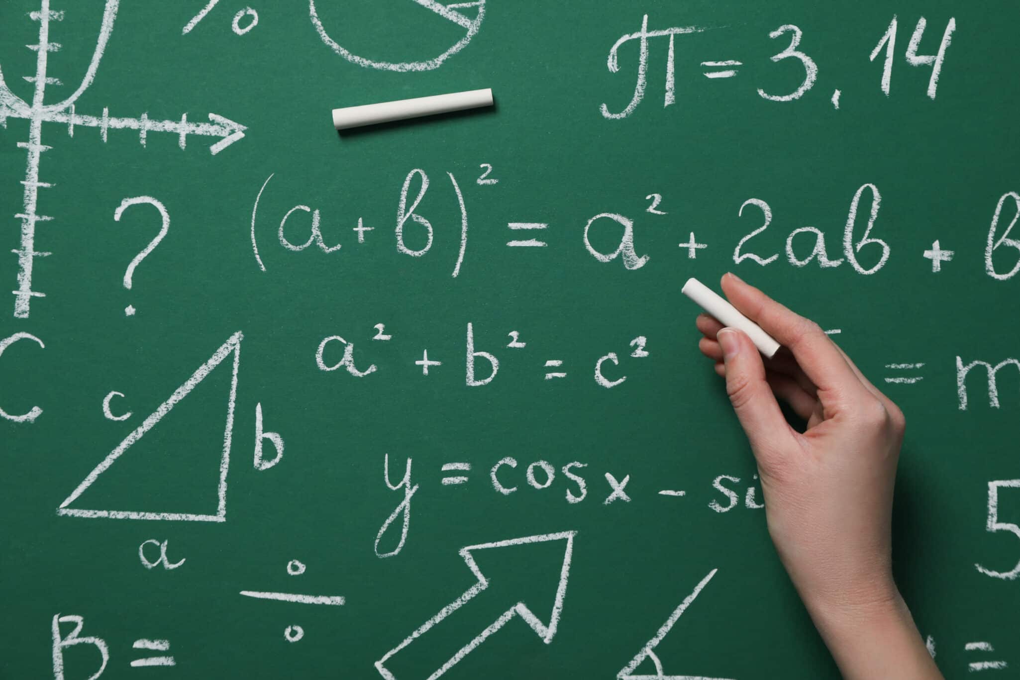 Green chalkboard filled with math equations representing genetic connection to mathematical ability