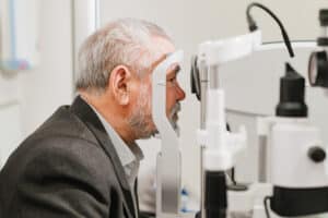 Man receiving an eye check-up to screen for cataracts, a condition that may have hereditary or genetic causes.