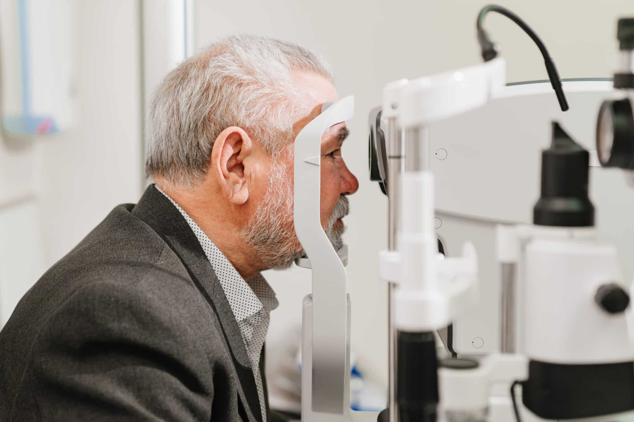 Man receiving an eye check-up to screen for cataracts, a condition that may have hereditary or genetic causes.