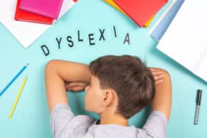 Child with dyslexia surrounded by jumbled letters representing reading difficulty.