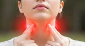 Woman with a red-highlighted neck, symbolizing thyroid inflammation — a key feature of Graves’ disease, which has known genetic links.